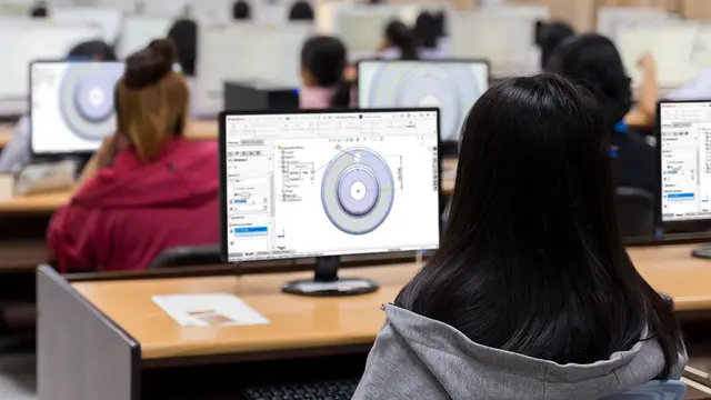 Students learning SOLIDWORKS on computers in a classroom